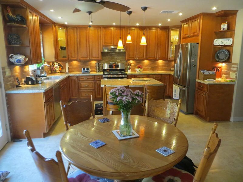 A kitchen with a table and chairs and a vase of flowers