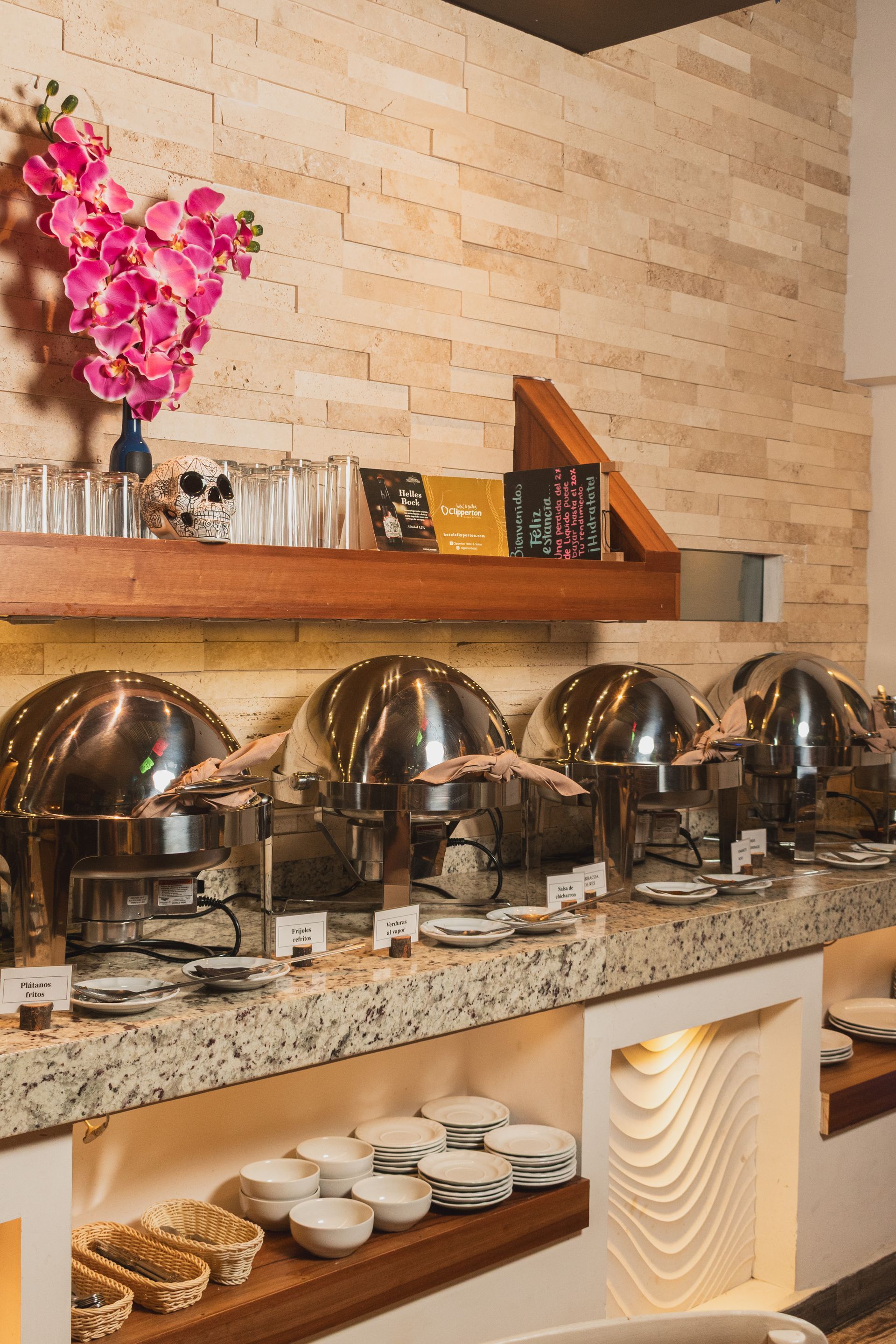 Restaurante  del hotel Clipperton Vercruz con  varias mesas redondas  y sillas alrededor e iluminacion en la habitación