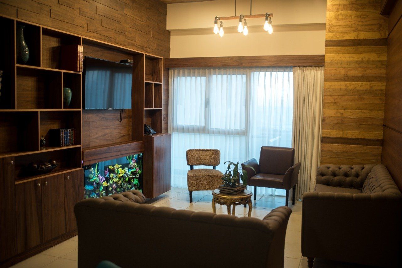 A living room with a couch , chairs , and a television.
