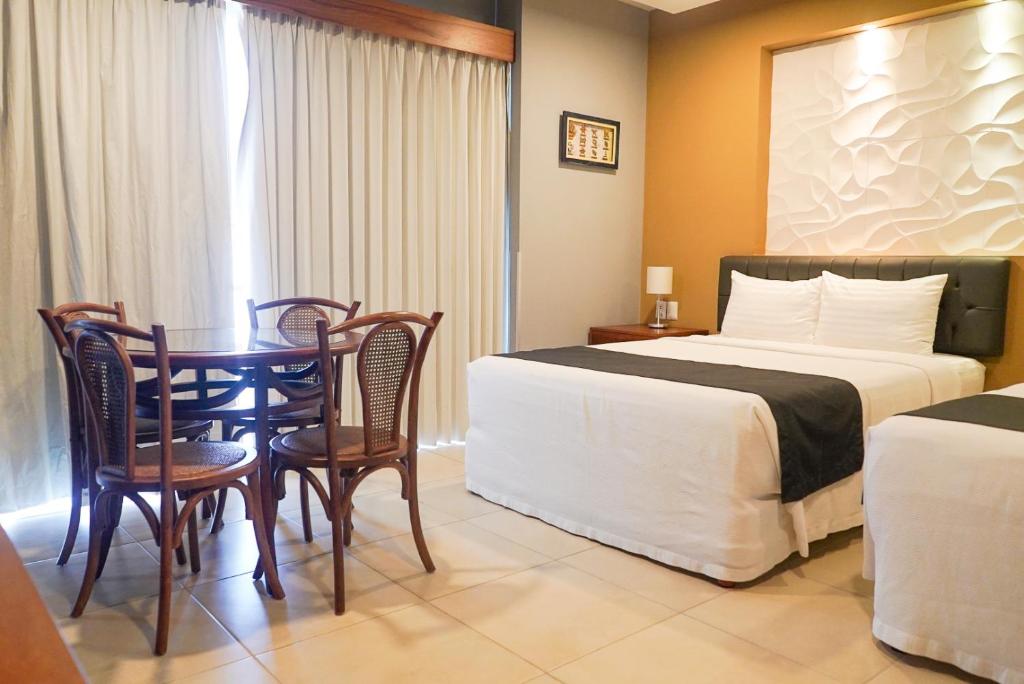 Una habitación de hotel con dos camas, una mesa y sillas.