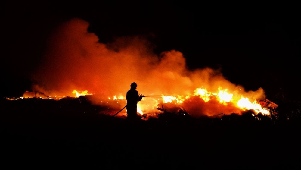 Firefighter Spraying Water on Nighttime Blaze - Hunter Valley NSW