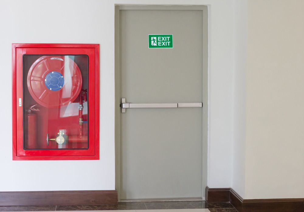 Red Fire Extinguisher Positioned Beside Exit Sign - Dubbo NSW