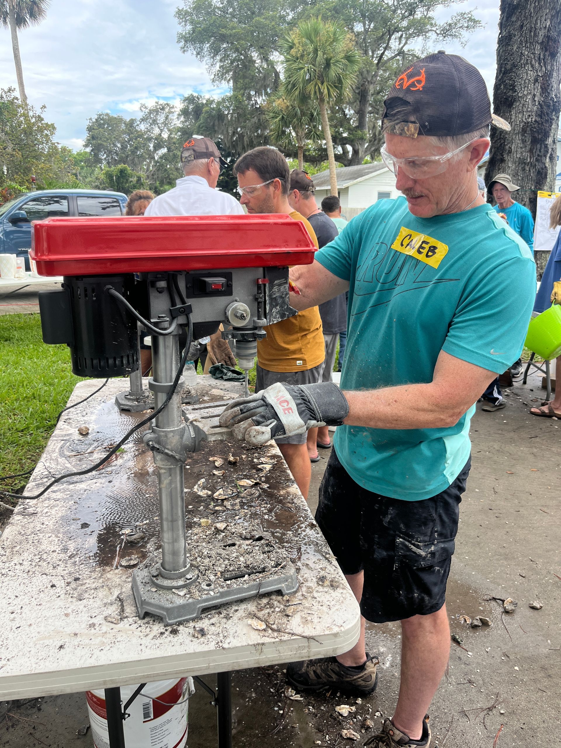A man is using a drill on a table.