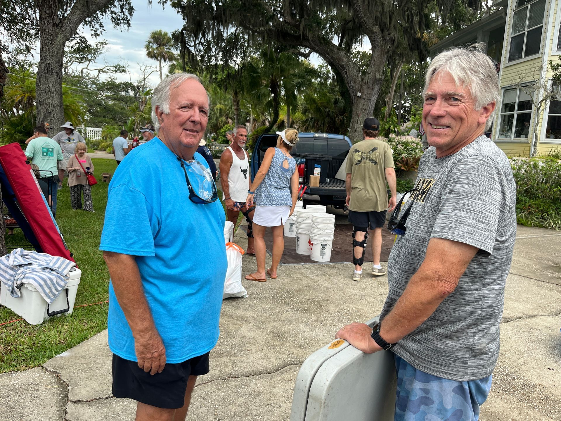Two men are standing next to each other on a sidewalk.