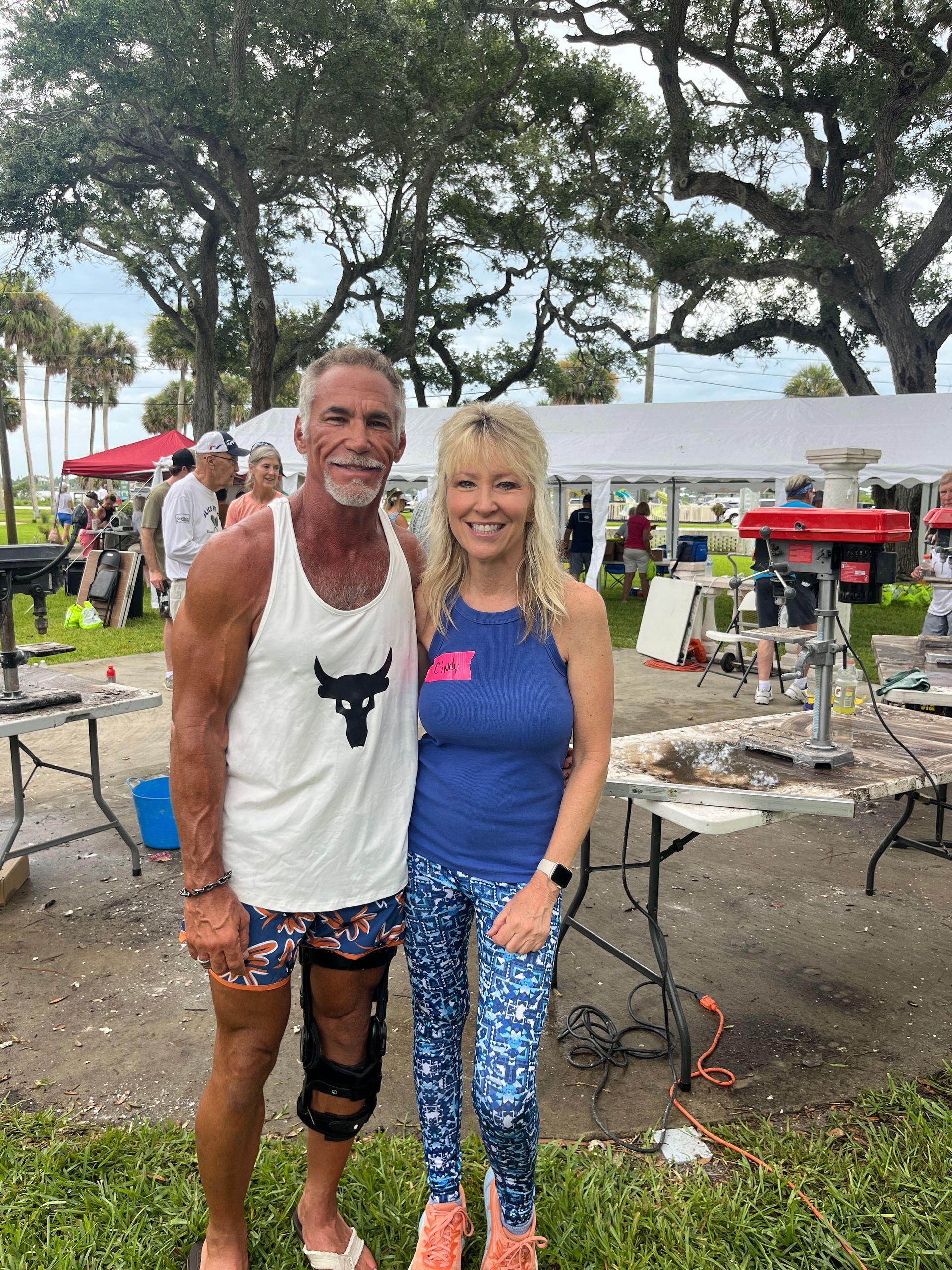A man and a woman are posing for a picture in a park.