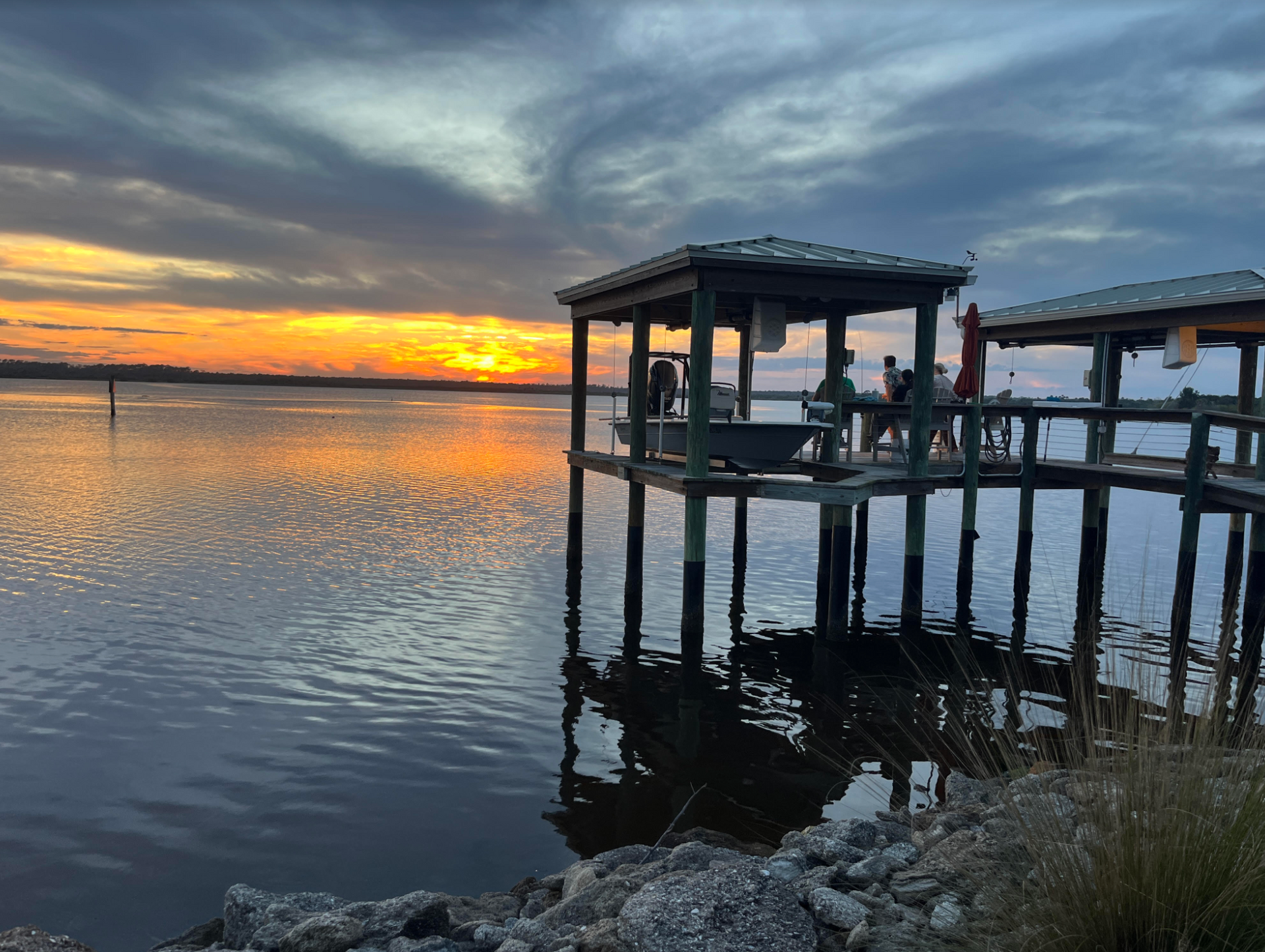 A sunset over a body of water with a dock in the foreground.