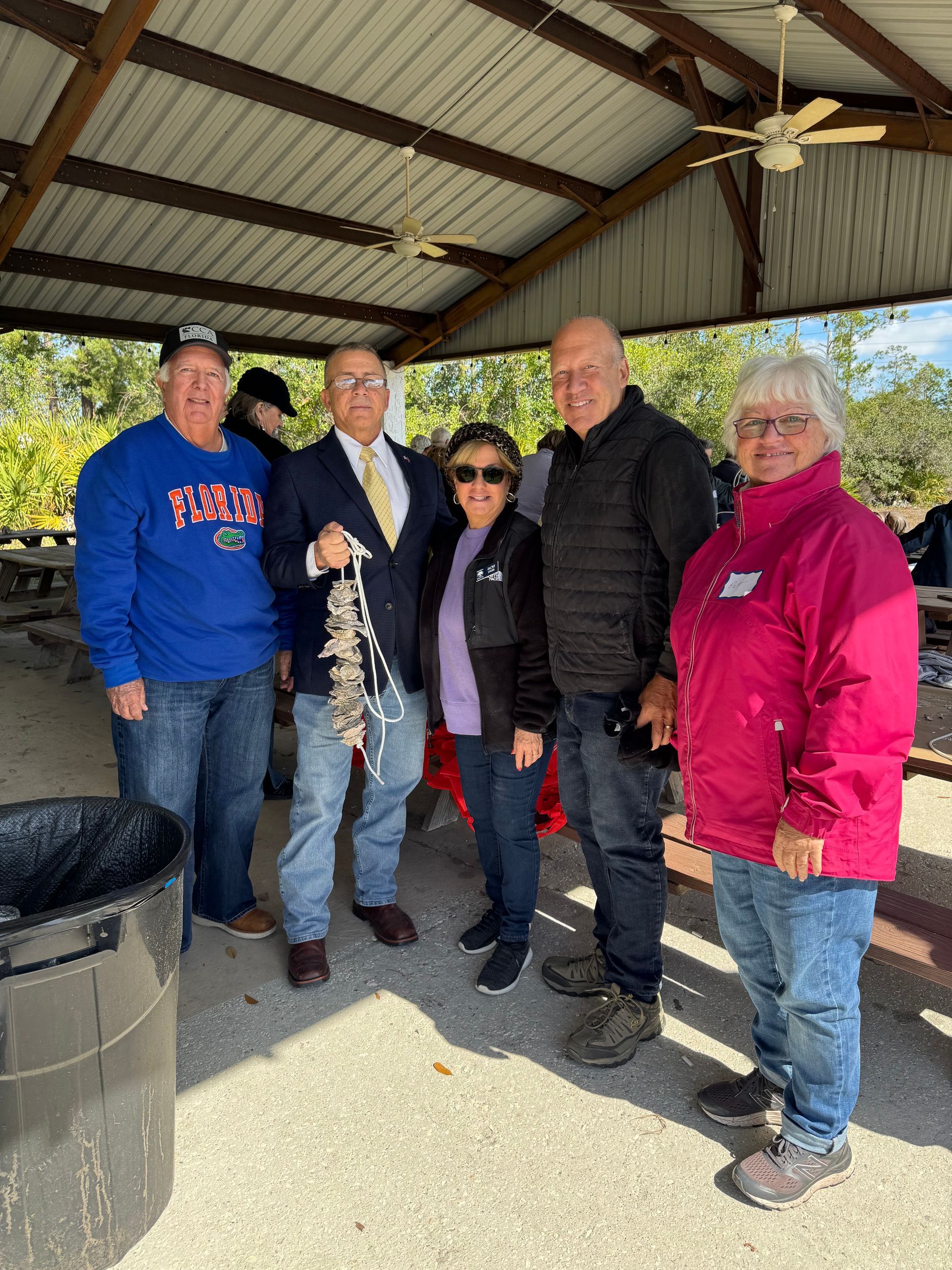 A group of people are posing for a picture under a pavilion.