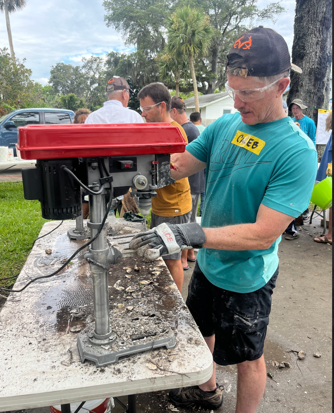 A man is using a drill on a table.