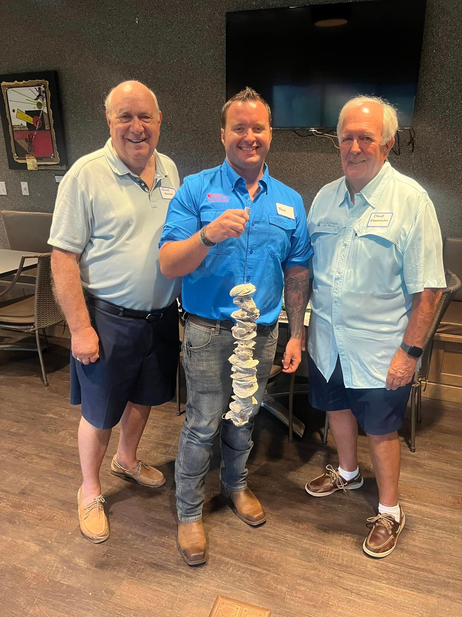 Three men are standing next to each other in a room.