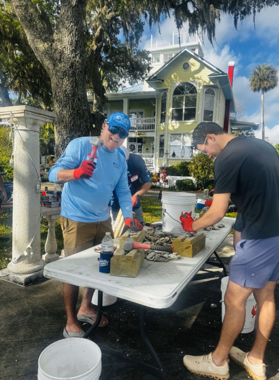 A group of people are standing on top of a lush green field.