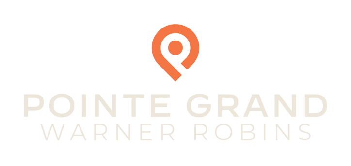 Pointe Grand Warner Robins logo in orange and white.