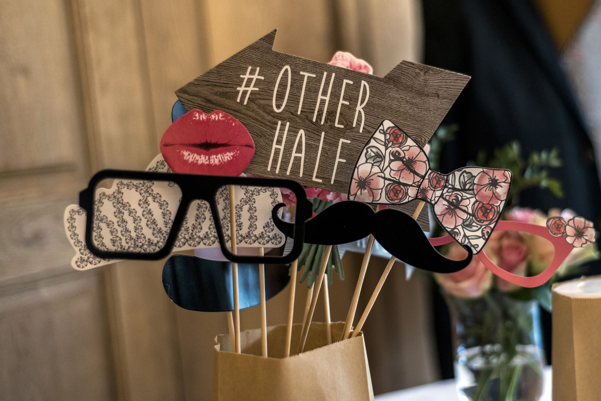 Photo booth props, including glasses, lips, mustache, bow tie, and an arrow with 