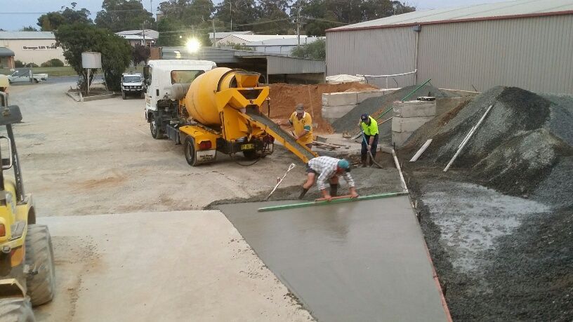 A concrete mixer truck is pouring concrete into a concrete ramp — Pigot's Midwestern Mini Mix In Orange, NSW