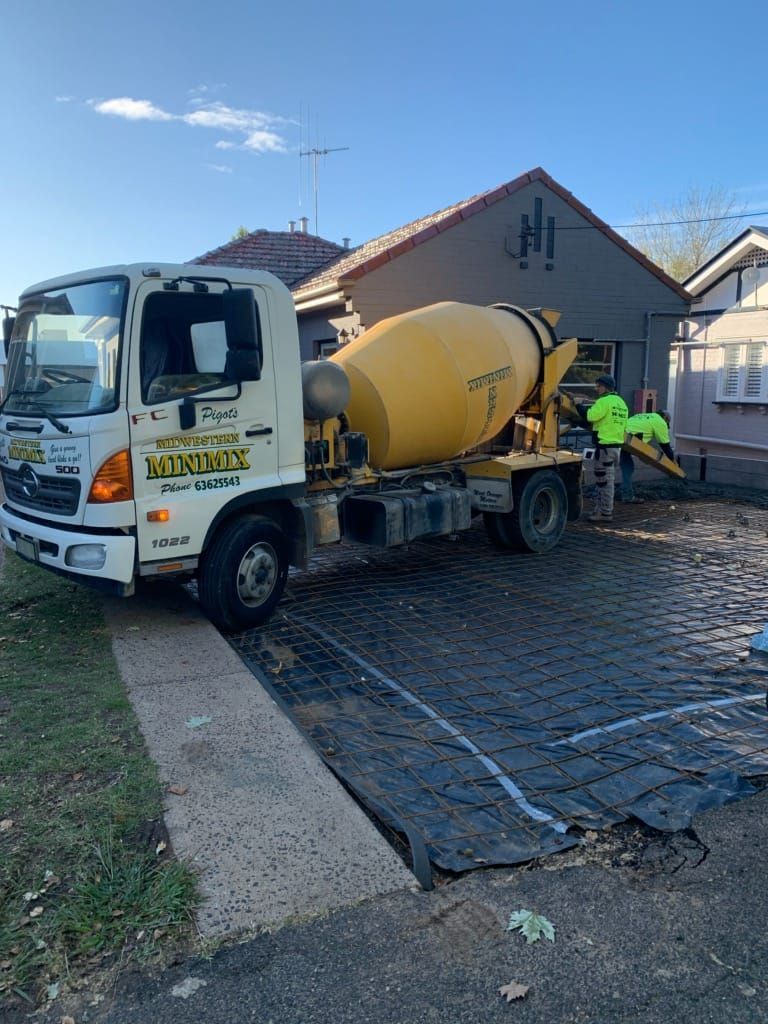 A Concrete Mixer Truck Is Parked In Front Of A House — Pigot's Midwestern Mini Mix In Orange, NSW