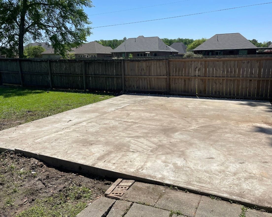 A concrete patio with a wooden fence in the background.