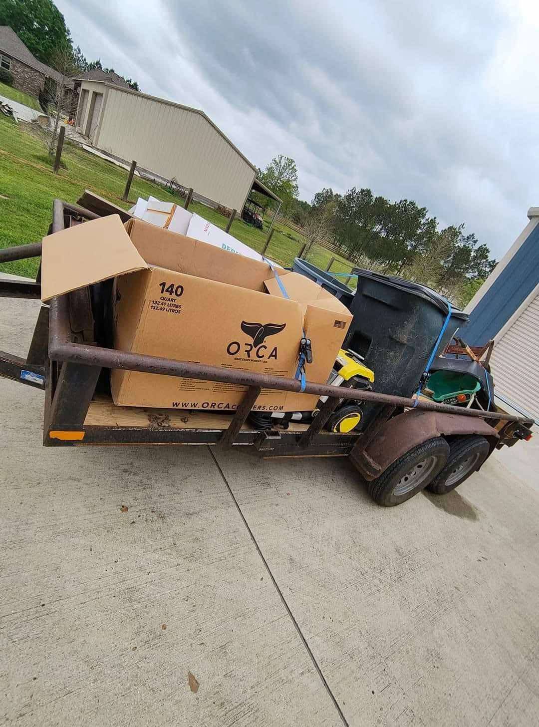 A trailer with boxes on it is parked on the side of the road.