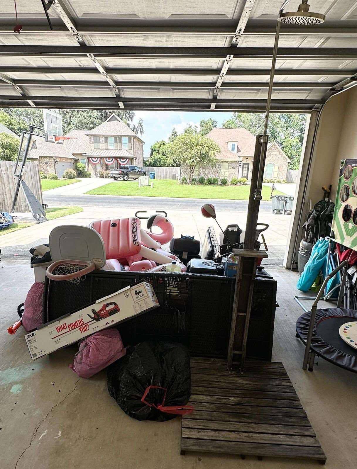 A garage filled with lots of junk and a trampoline.