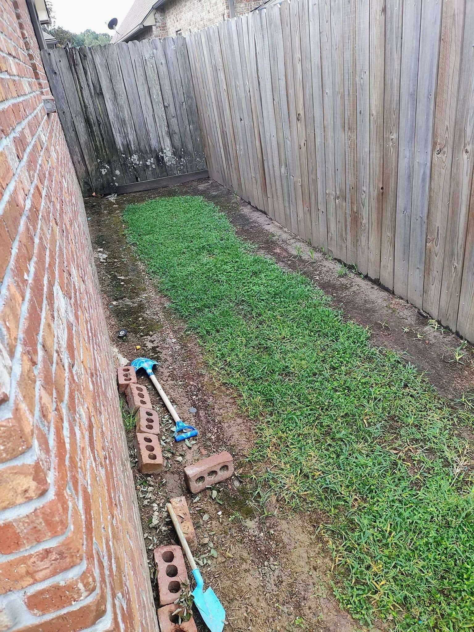 There is a brick wall and a wooden fence in the backyard.