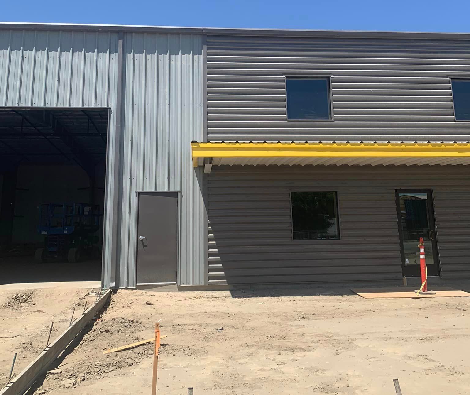 A large gray building with a yellow awning on the roof.