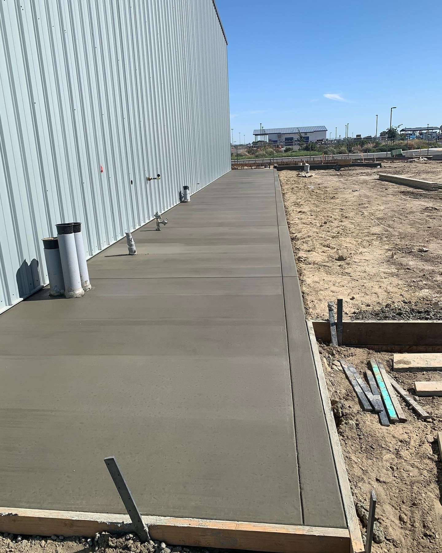 A concrete walkway is being built in front of a building.
