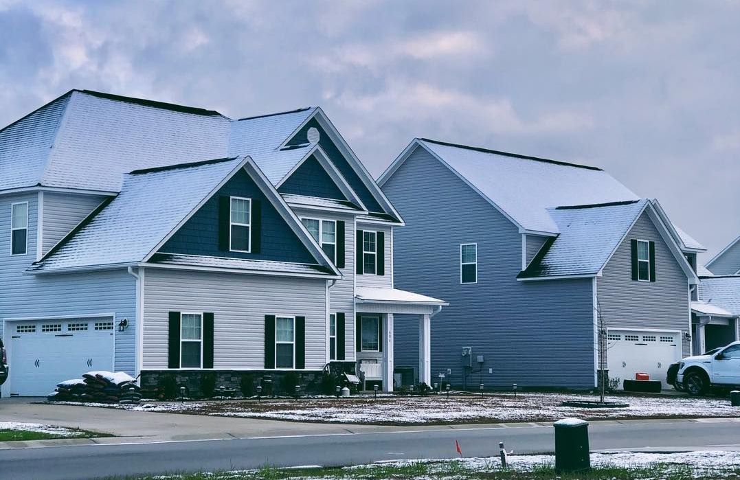 A row of houses with snow on the roofs