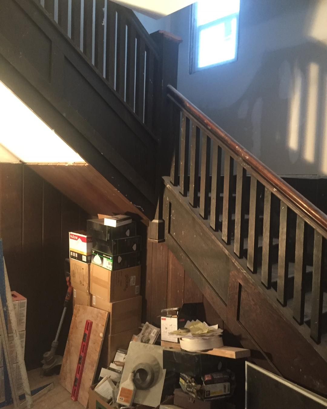 A wooden staircase with boxes on the bottom of it