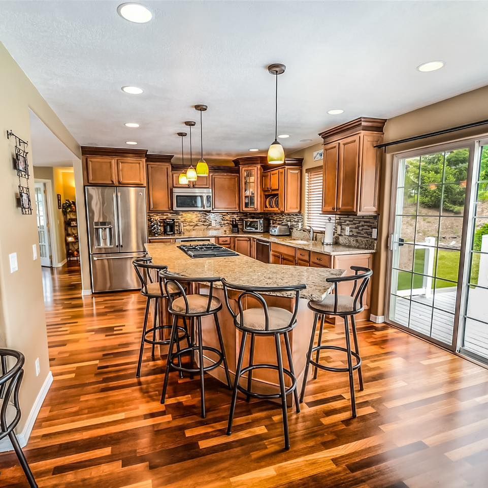 A kitchen with hardwood floors and stainless steel appliances