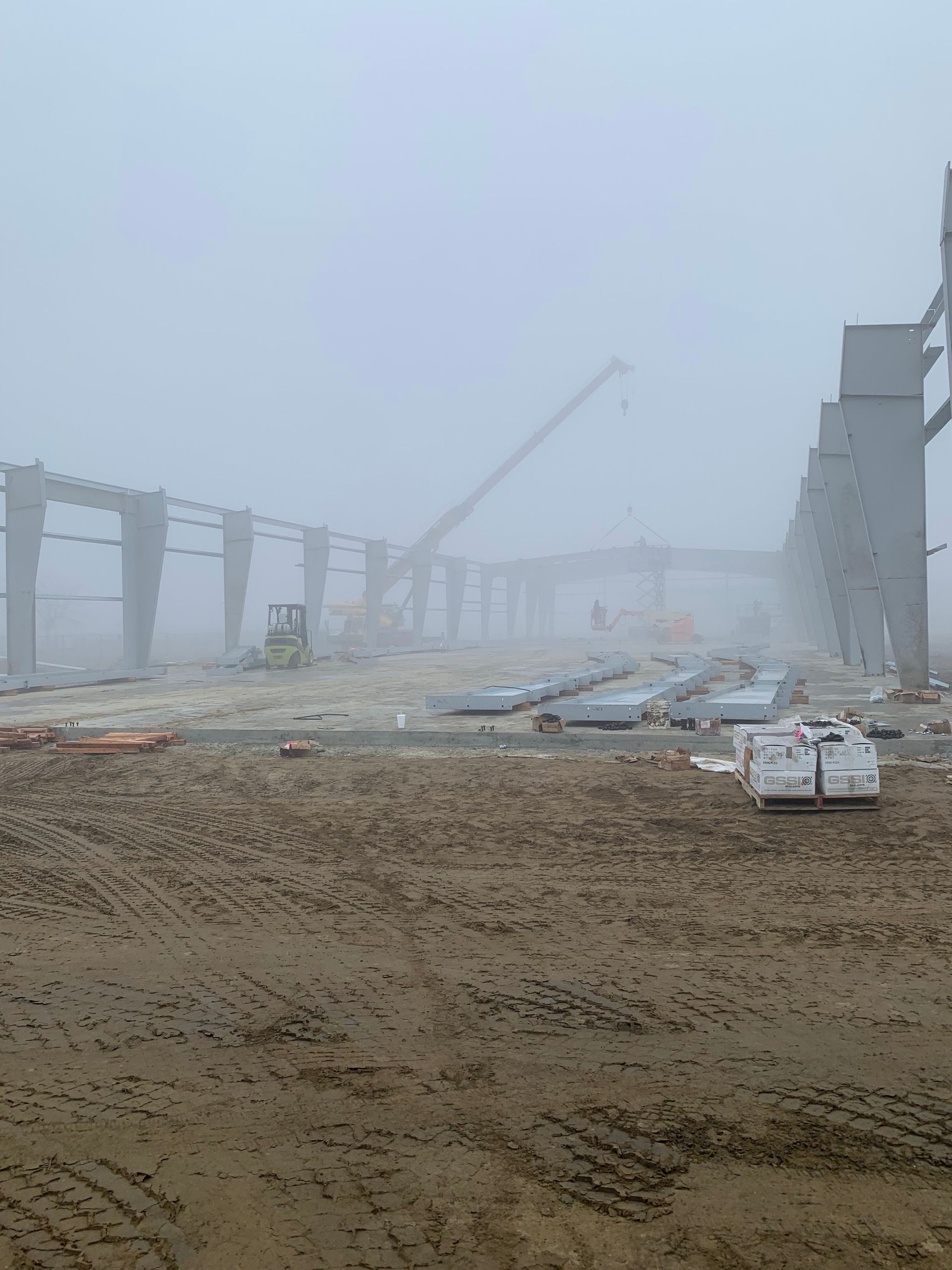 A construction site is covered in fog on a foggy day.