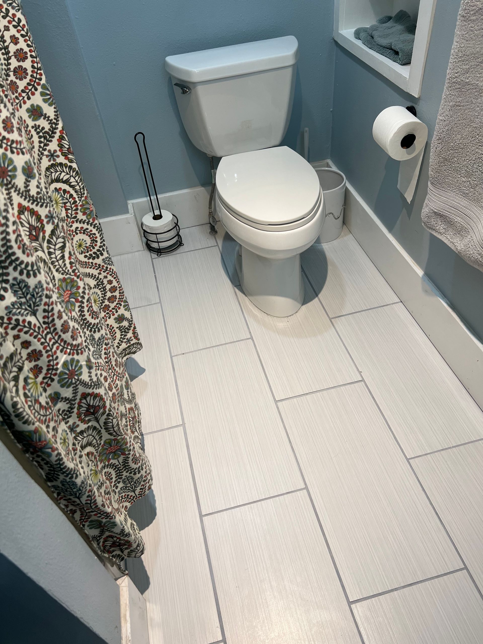 A bathroom with a toilet and a shower curtain