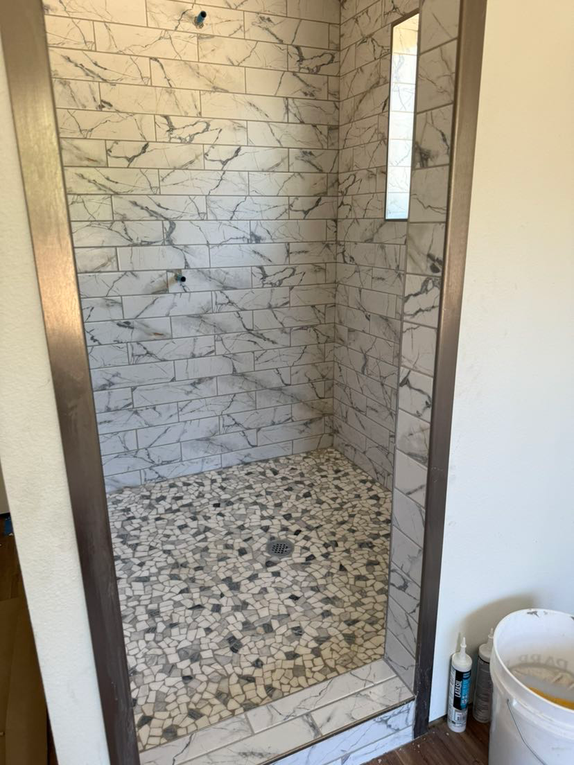 A bathroom with a walk in shower and a mirror.