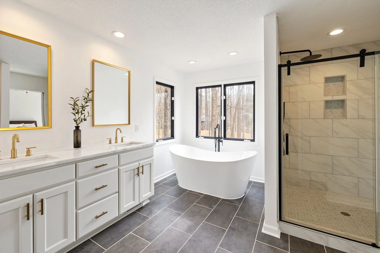 Bright modern bathroom with double vanity, freestanding tub, and glass walk-in shower