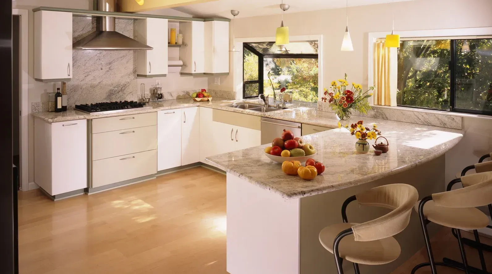 Modern kitchen with white cabinets, granite countertops, and an island with bar stools.