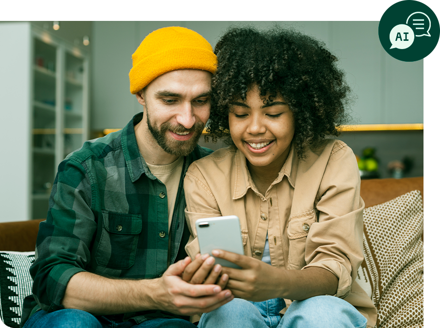 Um homem e uma mulher estão sentados em um sofá olhando para um celular.