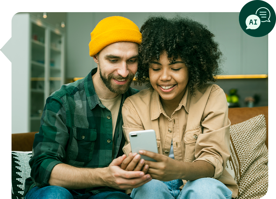 Um homem e uma mulher estão sentados em um sofá olhando para um celular.