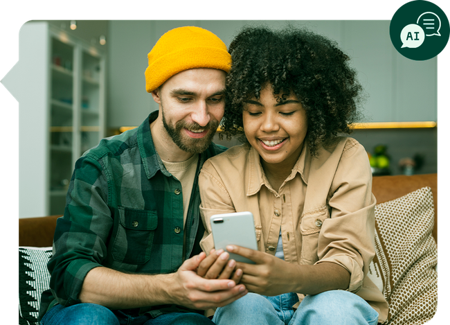 Um homem e uma mulher estão sentados em um sofá olhando para um celular.