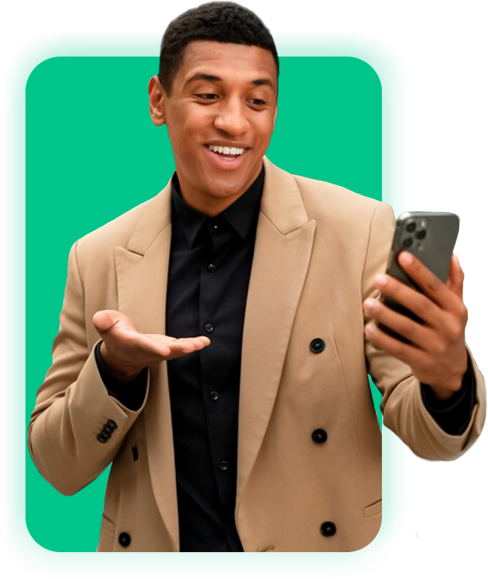 Um homem de terno está segurando um celular e sorrindo.
