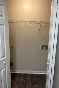 A closet with a wooden floor and a clothes rack.