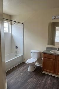 A bathroom with a toilet , sink and bathtub.
