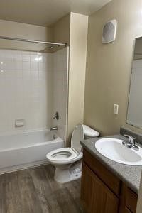 A bathroom with a toilet , sink and bathtub.