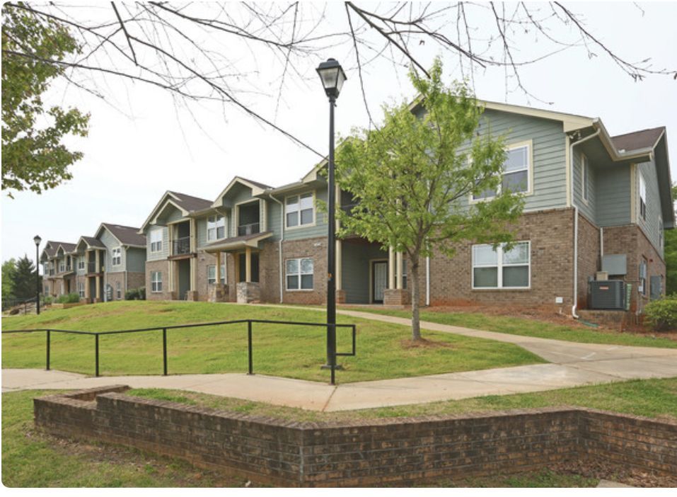 A row of apartment buildings with a sidewalk in front of them