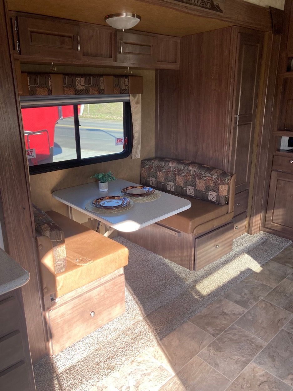 RV interior with a booth seating area and a table.