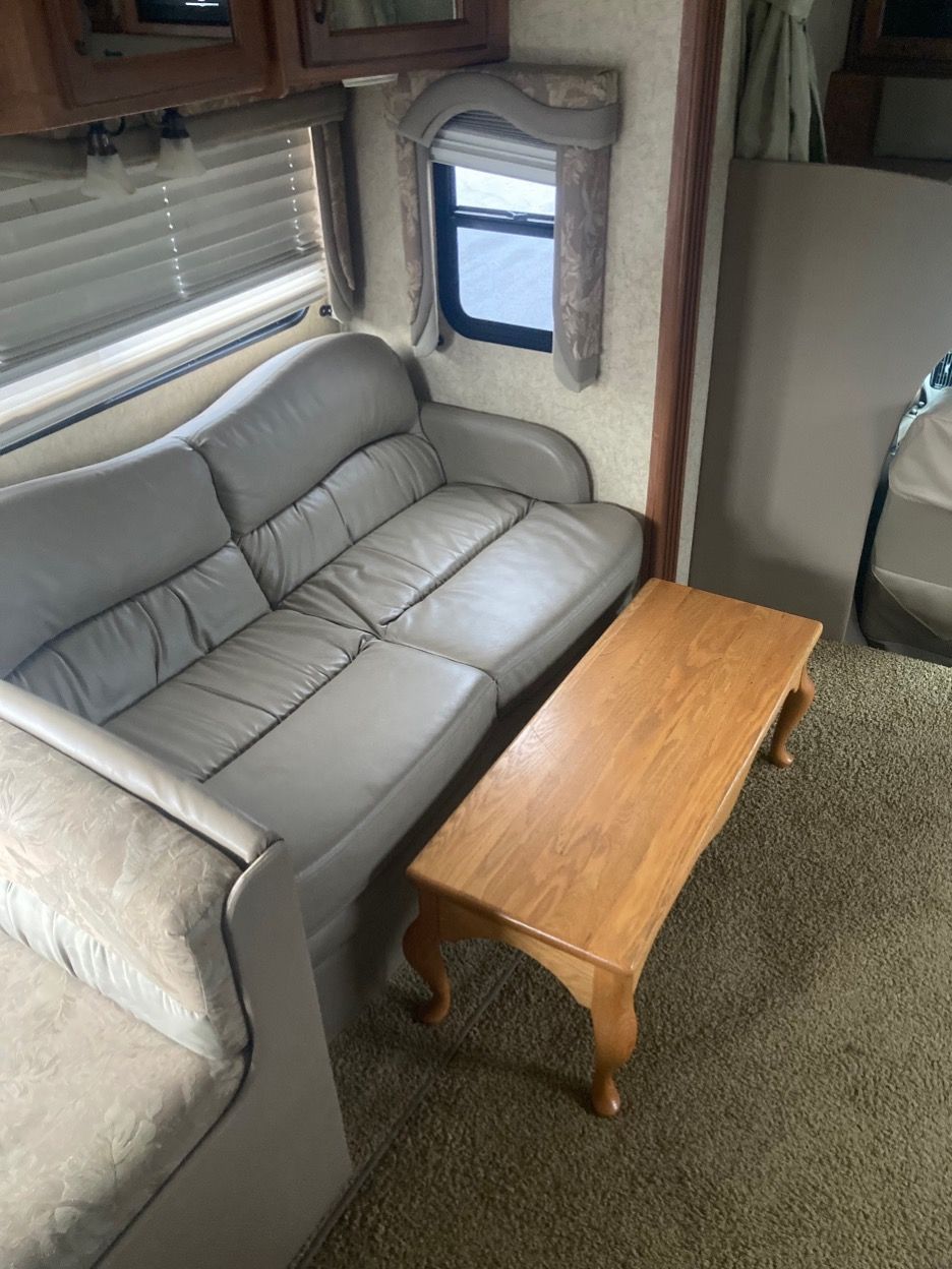 Grey sofa and wooden coffee table in a camper interior.
