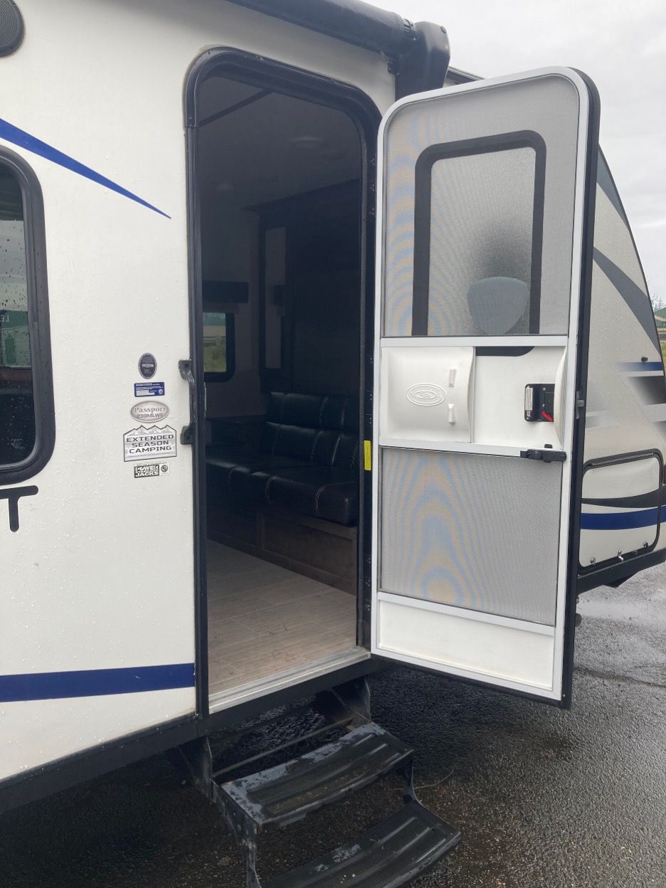 RV doorway with open screen door and two entry steps.