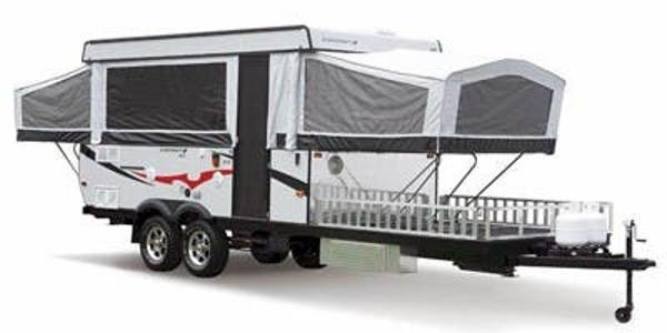 White pop-up camper with black accents, sitting on a trailer hitch.