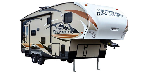 Tan and brown Fox Mountain fifth wheel RV parked on leveling jacks.