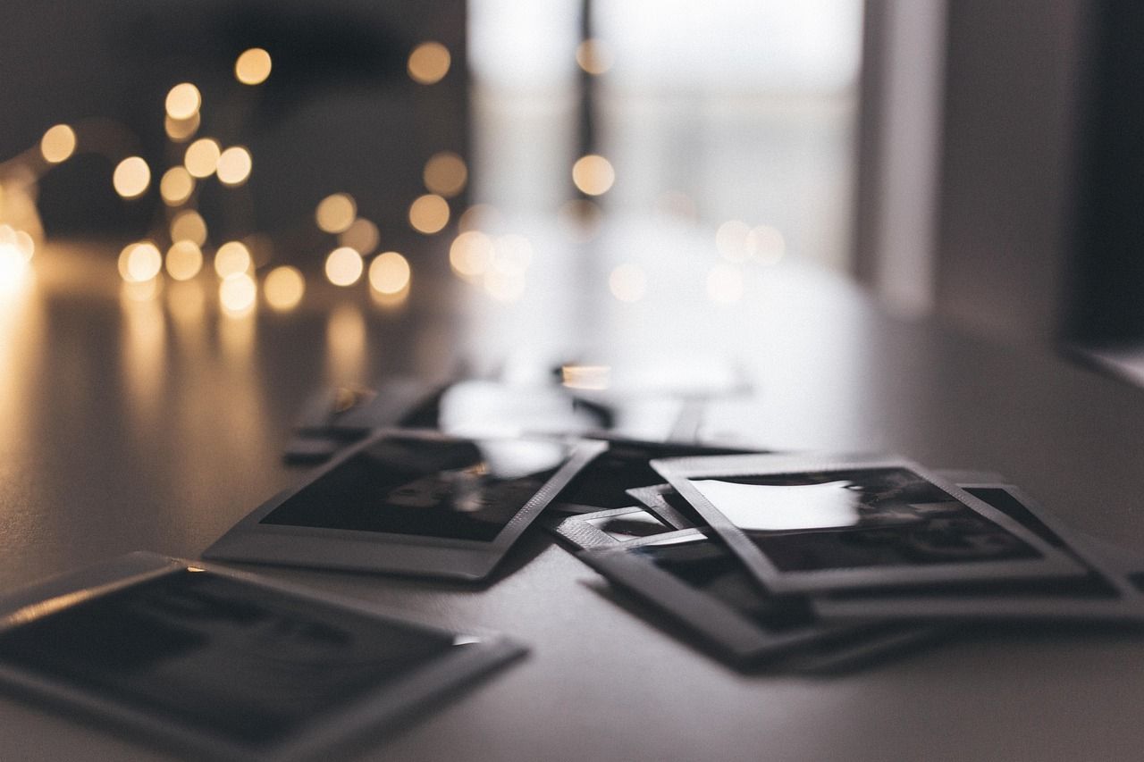 Polaroids over a table, with fairy lights in the back