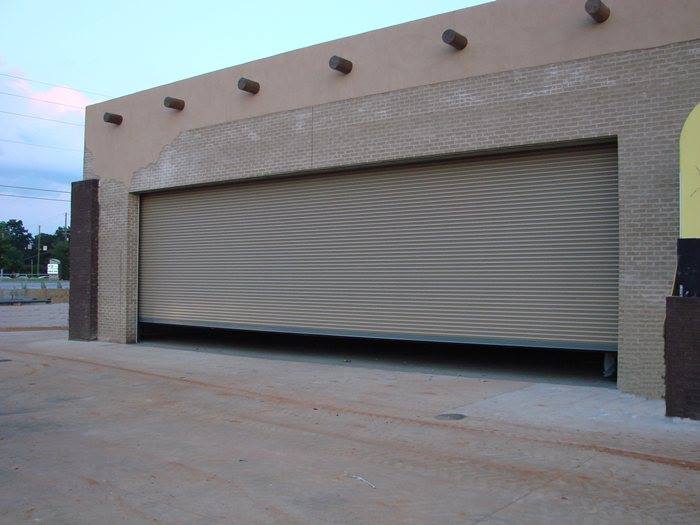 A large garage door is open on a brick building
