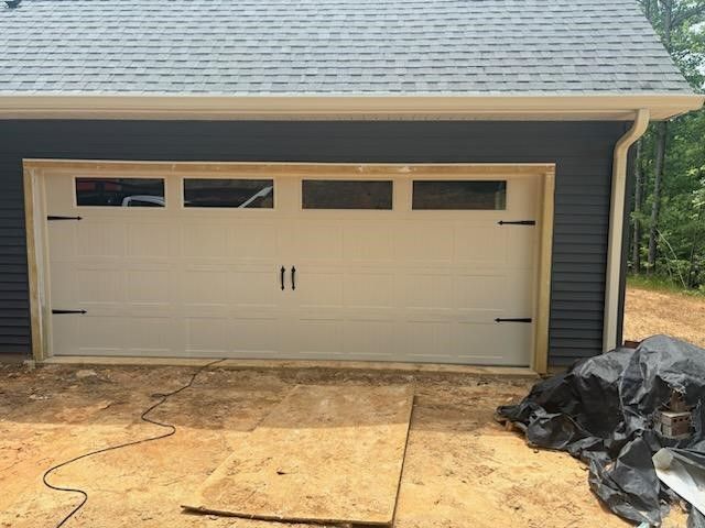 A garage door is being installed on a house.