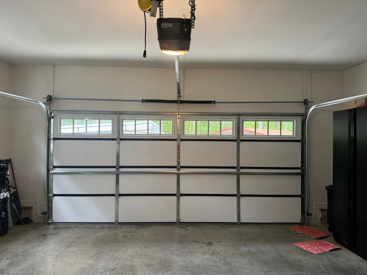 A garage with a white door and a garage door opener