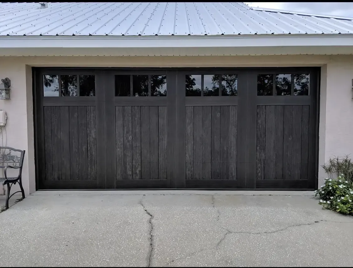 A large wooden garage door with a metal roof